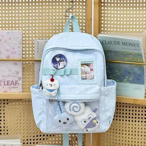 Dettaglio zaino ita azzurro a pois con tasca trasparente, badge anime e simpatici peluche.