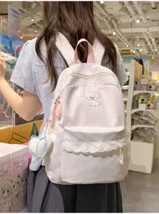 Detailweergave van de roze ruitjes rugzak met schattige kanten volants en lief puppy borduurwerk.