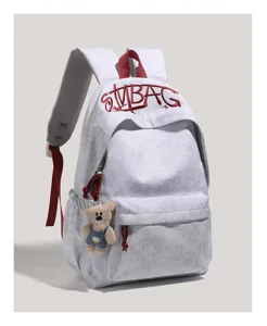 Grey canvas backpack with red straps, embroidered letter design, large capacity for daily commute.
