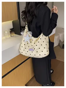 Gedetailleerd overzicht van de trendy stippen schoudertas voor dames met een chique ontwerp.