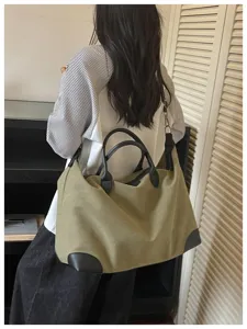Grote casual reistas van kaki canvas met zwarte lederen handgrepen voor vrouwen.