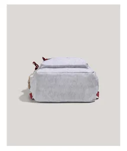 Detailed view of the grey casual backpack showing texture fabric, red strap and side plush pendant.