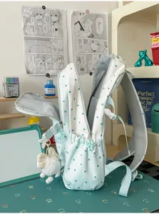 Vue détaillée du sac à dos bleu clair étoilé avec charm peluche et rangements.