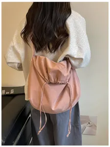 Vue détaillée du sac bandoulière rose souple à cordon, grande capacité, style fourre-tout.