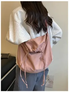 Vue détaillée du sac bandoulière rose décontracté à cordon et sac porté épaule chic.