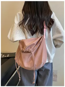 Vue de détail du sac bandoulière rose à cordon, grand sac souple hobo style messager fourre-tout.