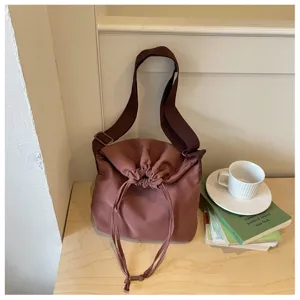 Vue détaillée d'un sac bandoulière à cordon confortable en couleur unie avec sangle.