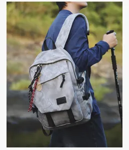 Vue détaillée d'un sac à dos camouflage gris montrant une grande capacité et des poches.