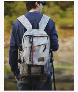 Vue de détail lifestyle en extérieur du sac à dos camouflage gris porté par un étudiant.
