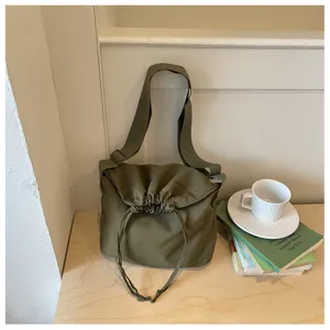 Vue détaillée du sac bandoulière minimaliste vert olive avec cordon de serrage ample.