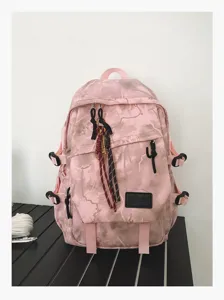 Vue détaillée du sac à dos d'école rose camouflage avec des sangles et de beaux pendentifs.