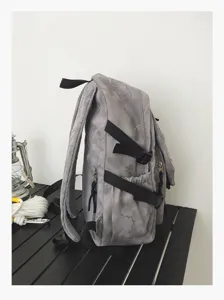 Détail latéral du sac à dos gris motif montrant des sangles solides et une poche latérale.