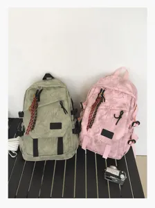 Grand sac à dos scolaire élégant en vert et rose avec de multiples poches pratiques.