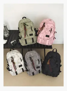 Sacs à dos étudiants multicolores présentés sur une table noire, vue de détail.