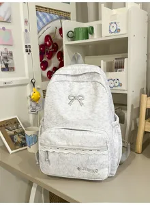 Gedetailleerd overzicht van een grijze rugzak in Japanse stijl met strik borduurwerk.