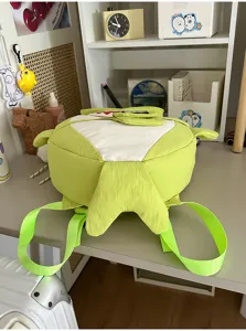 Gedetailleerd uitzicht op de schattige haaienvormige kinderrugzak, groen waterdicht design voor reis.