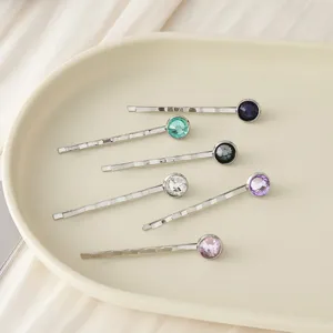 Detailansicht eleganter Metallhaarnadeln verziert mit bunten glitzernden Kristall-Strasssteinen.