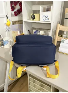 Gedetailleerd overzicht van donkerblauwe rugzak met heldergele banden op het bureau.