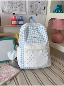 Detail van blauw-witte ruitjes rugzak met stippen volant en schattig hondjesontwerp.