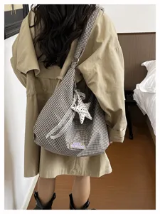 Gedetailleerd opname van een stijlvolle ruitjes hobo tas met kant en schattige sterrenhanger.