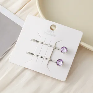 Detailansicht einfacher lila Kristall Metall Haarklammern auf weißer Karte, Accessoire.