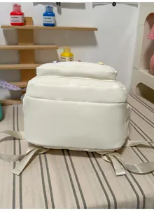 Gedetailleerd overzicht van een witte studentenrugzak met canvas textuur en stevige banden.