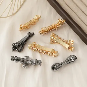 Metal hair clips close up, assorted gold and gunblack bows and floral designs for daily wear.