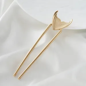 Close-up view of the gold mermaid tail U-shaped hair fork, showing fine details and smooth finish.