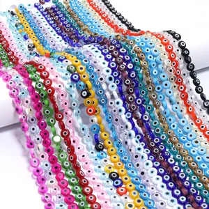 Close up of colorful transparent evil eye glass flat round beads for DIY jewelry crafts.