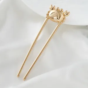 Gold U-shaped hair fork detail, cute crab design, smooth metallic finish for styling.