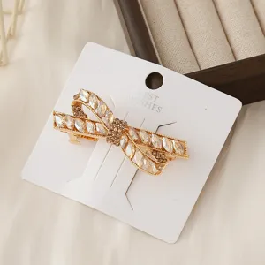 Detailed close-up view of a sparkling crystal bow hair clip elegantly displayed on card.