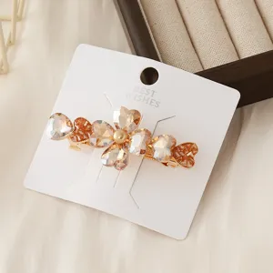 Exquisite crystal heart hair clip detail showing sparkling champagne stones and display card.
