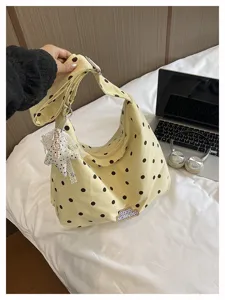 Gedetailleerd overzicht van de gele schoudertas met stippen en schattige kanten hanger.