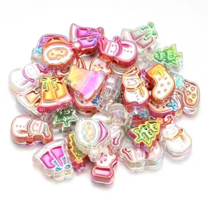 Vue détaillée de perles de Noël acryliques aux formes de bonhomme de neige et de cloche.