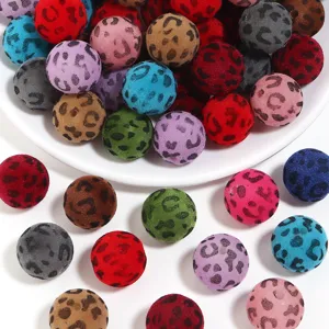 Gros plan de boules artisanales flockées léopard colorées de 16 mm, idéales pour accessoires.