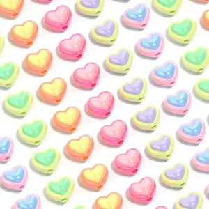 Vista detallada de cuentas acrílicas en forma de corazón chapado UV pastel brillante para joyas.