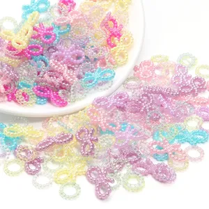 Gros plan de nœuds et cercles en perles ABS dégradées colorées pour bijoux DIY.