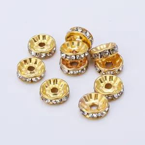 Gold rhinestone rondelle spacer beads detail, wave shaped metal charms for DIY jewelry making.