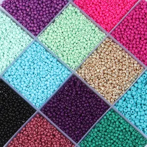 Detailed macro view of vibrant colorful 2mm glass seed beads sorted in storage box.