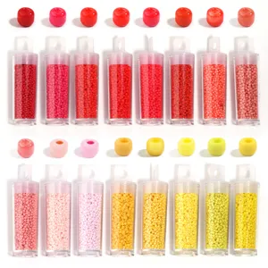 Gros plan détaillé de petites perles de verre colorées de 2mm pour la création de bijoux.