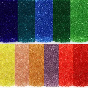 Détail en gros plan de rocailles en verre transparent de 2 mm aux couleurs variées pour bijoux.