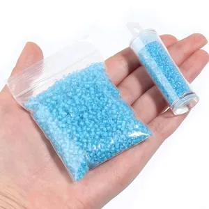 Light blue glass seed beads in bag and tube, 3mm transparent DIY bracelet craft supplies detail.
