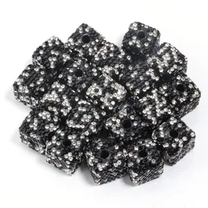 Gros plan perles cubiques strass argile noire, idéal création bijoux DIY et accessoires.