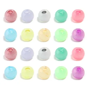 Gros plan de perles de verre rondes et colorées, finition brillante pour bijoux DIY.