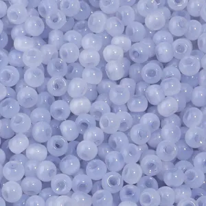 Gros plan détaillé de perles de rocailles en verre bleu clair, texture lisse, idéal pour bijoux DIY.