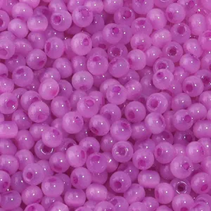 Gros plan détaillé de perles rocailles en verre violet, parfaites pour les bijoux DIY.
