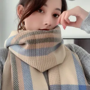 Detail view of a cozy plaid winter scarf, soft cashmere-feel fabric, warm daily accessory.