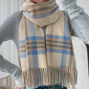 Detailed close-up of the stylish plaid scarf with soft cashmere-feel fabric and fringe hem.
