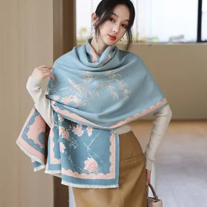 Vista dettagliata dell'elegante sciarpa blu effetto cashmere con stampa floreale e bambu.