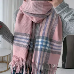 Pink plaid scarf detail view, showing soft imitation cashmere texture and tassel trim.